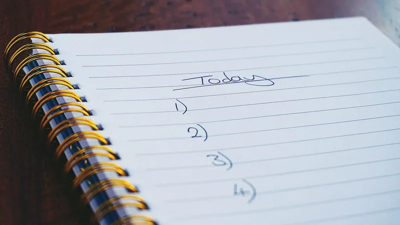 A handwritten checklist on a notebook — the structure that replaces open-ended research loops