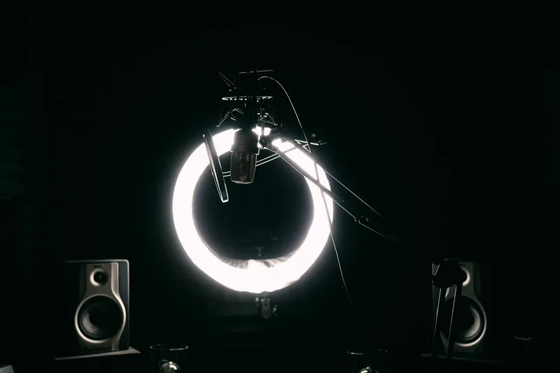A creator at a professional home studio setup with a ring light and microphone, deep in course production