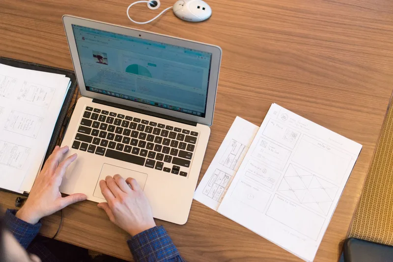A person at a laptop looking at multiple browser tabs with search results and competitor research open
