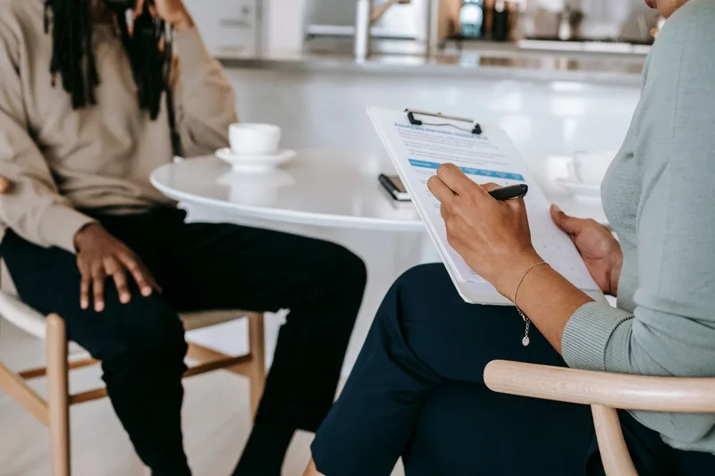 A researcher taking structured notes during a customer conversation about a recurring work problem