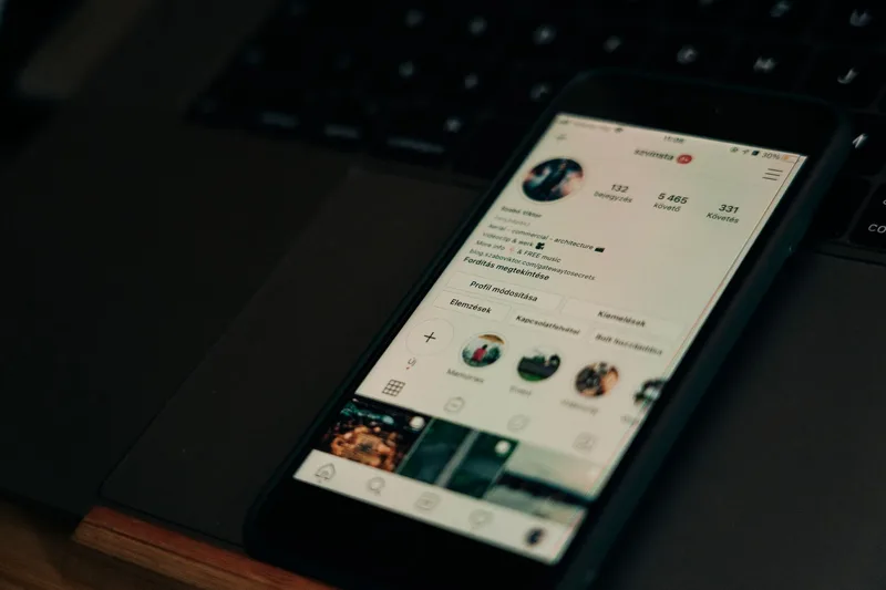 A smartphone showing a social media screen next to a laptop, representing the gap between engagement and purchasing intent