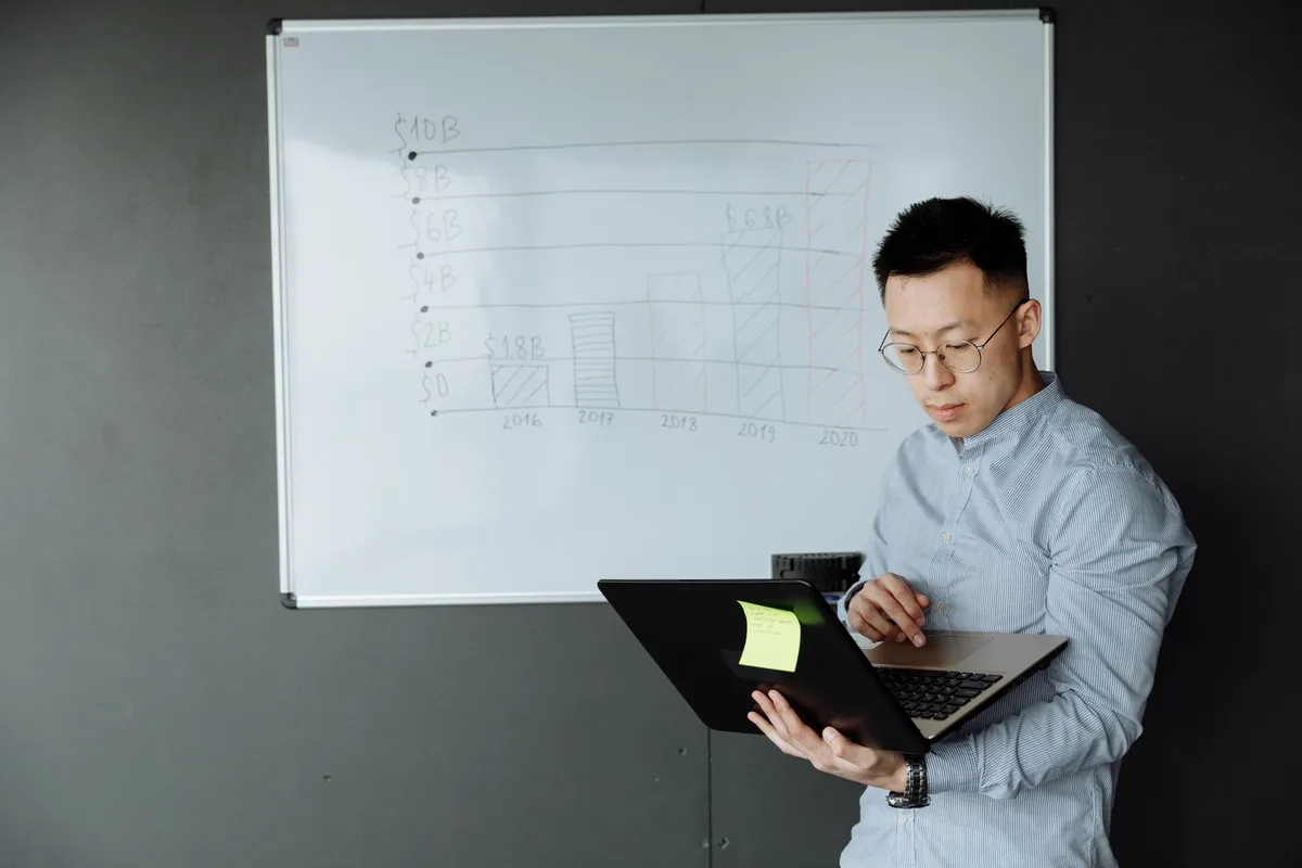A solopreneur reviewing poll results on a phone, looking thoughtful rather than excited, with a notebook open beside them