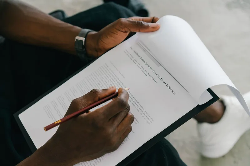 A person writing on a worksheet analyzing business signals — representing the signal evaluation process