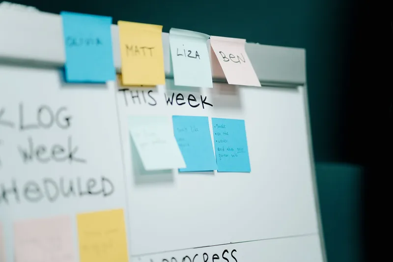 A whiteboard covered in colorful sticky notes mapping out customer personas and problem statements